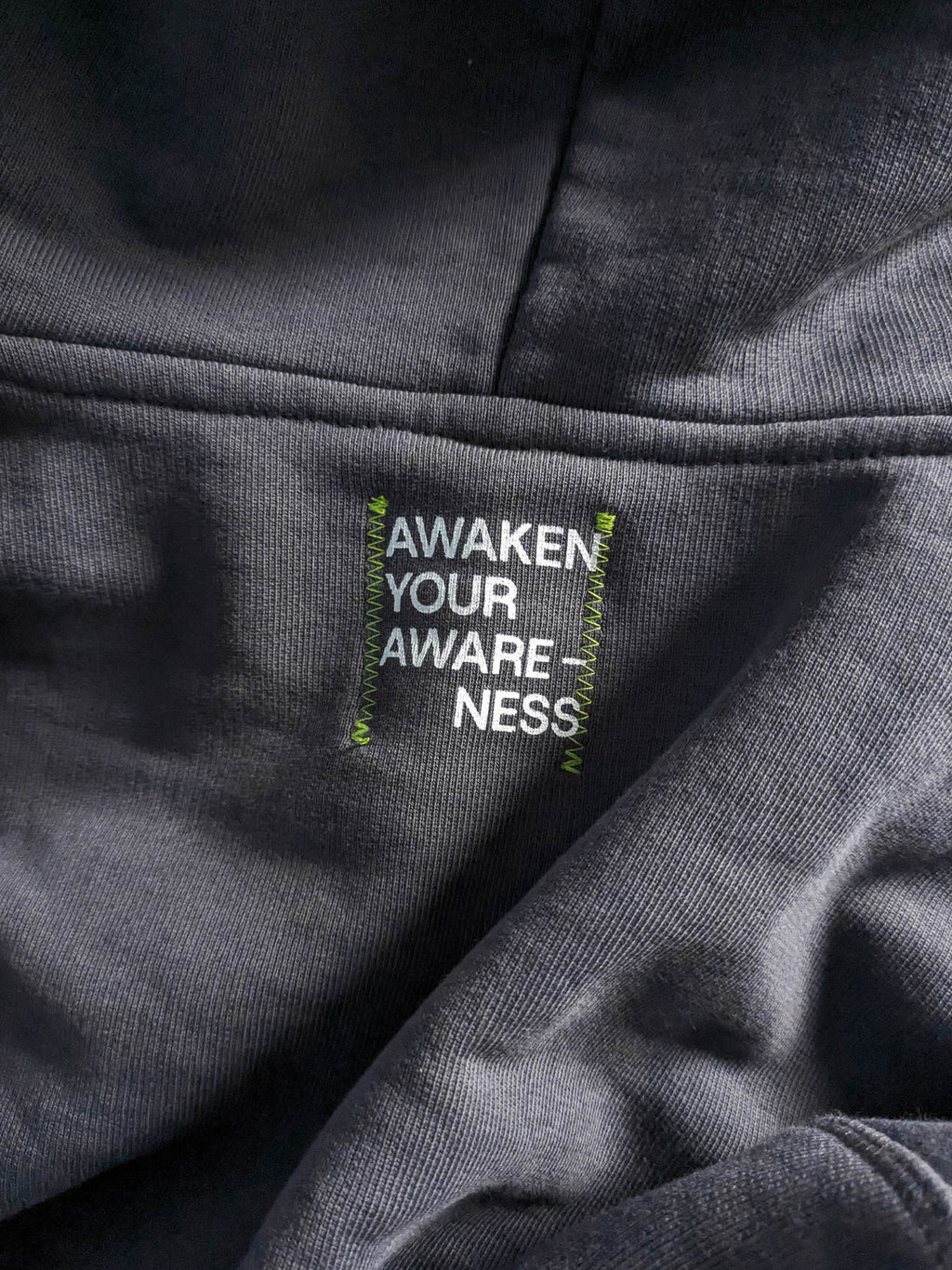 Text label on a gray fabric with a moto.